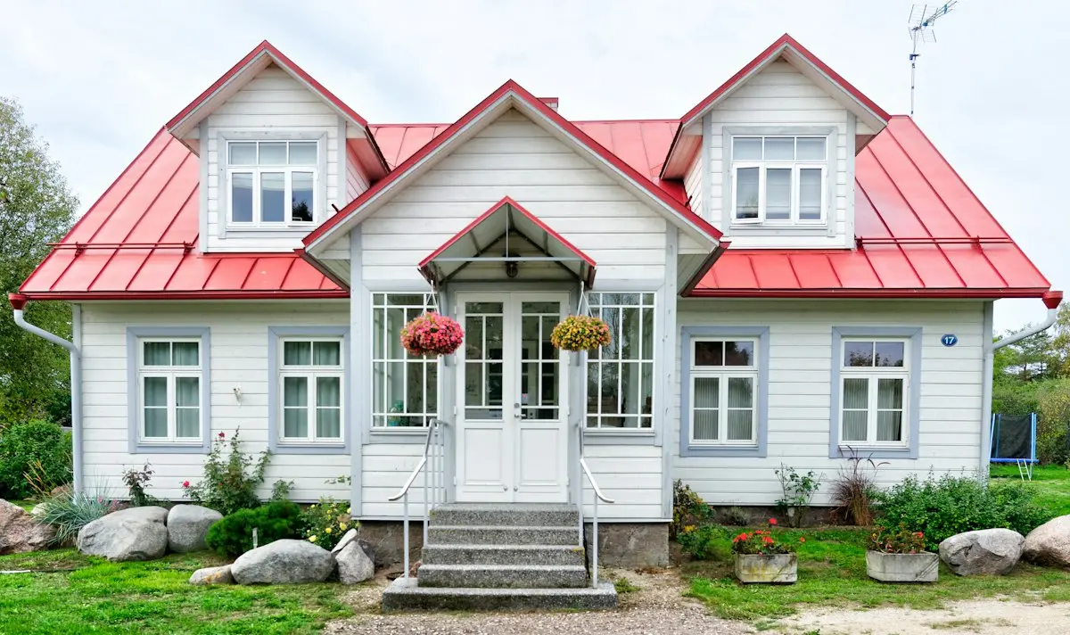 Maison blanche au toit rouge et son jardin