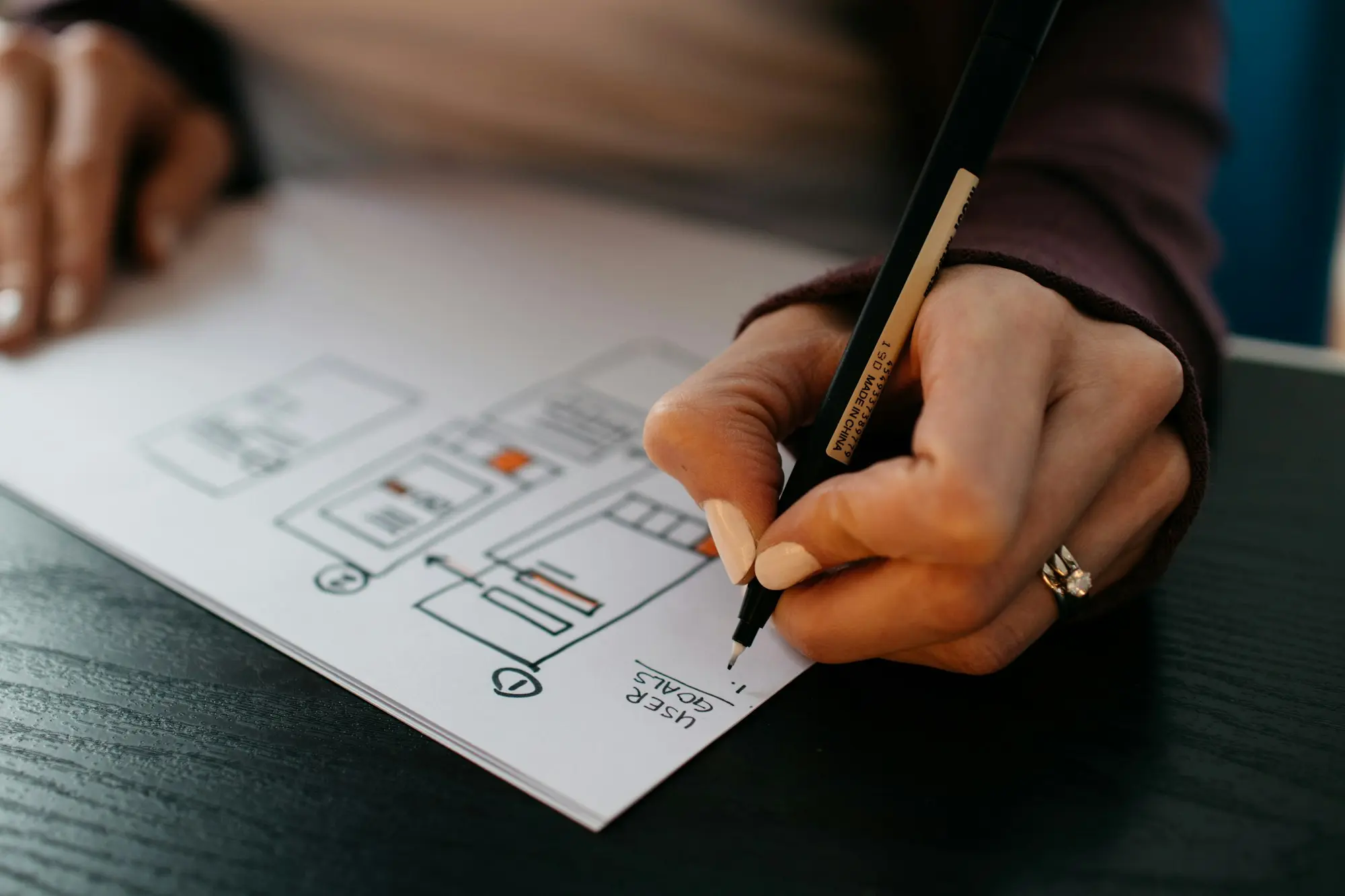 Main qui dessine un plan de bâtiment