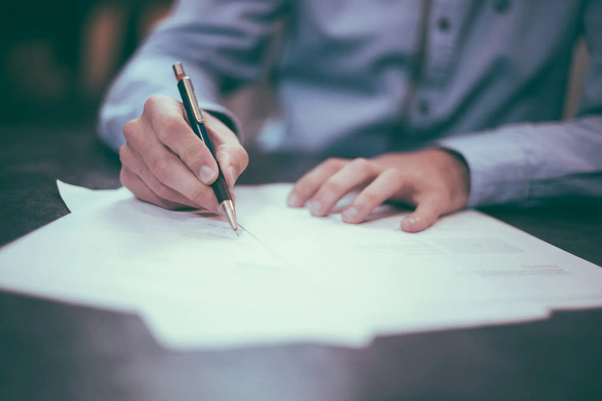 Main qui signe un document
